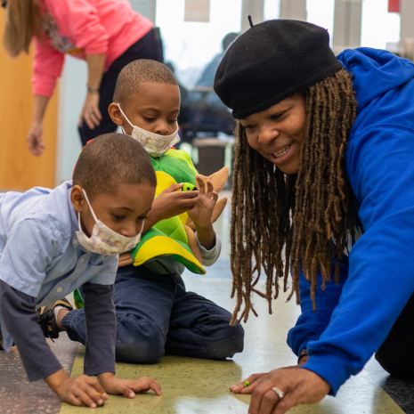 Founder of Literacy and More, Rachel Honore, playing with children during a sensory event.